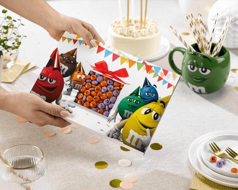 Eine Person, die eine M&M'S-Box anbietet