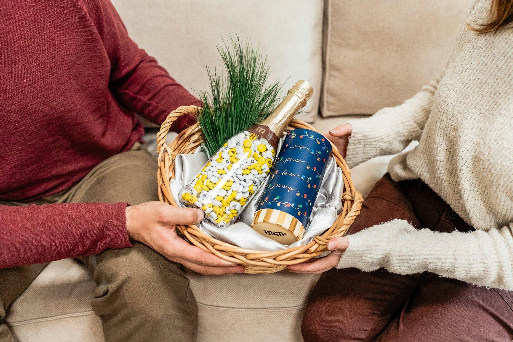 two people exchanging an occasion bottle with personalized M&M'S