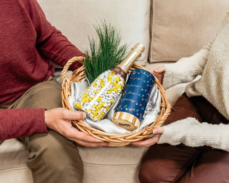 two people exchanging an occasion bottle with personalized M&M'S
