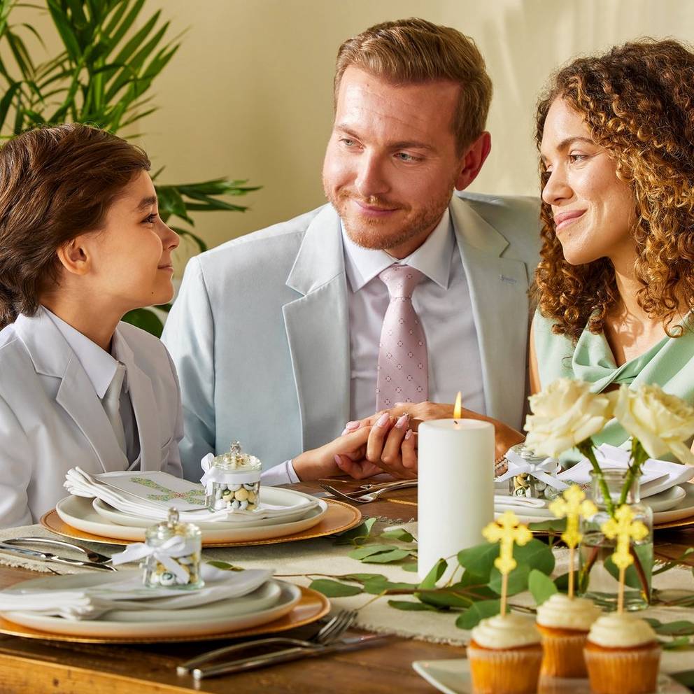 padres celebrando la primera comunión de su hijo con M&M'S personalizados en la mesa