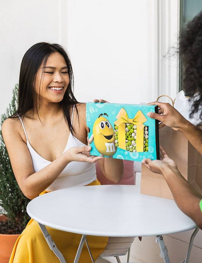 due donne con scatola di compleanno M&M'S®