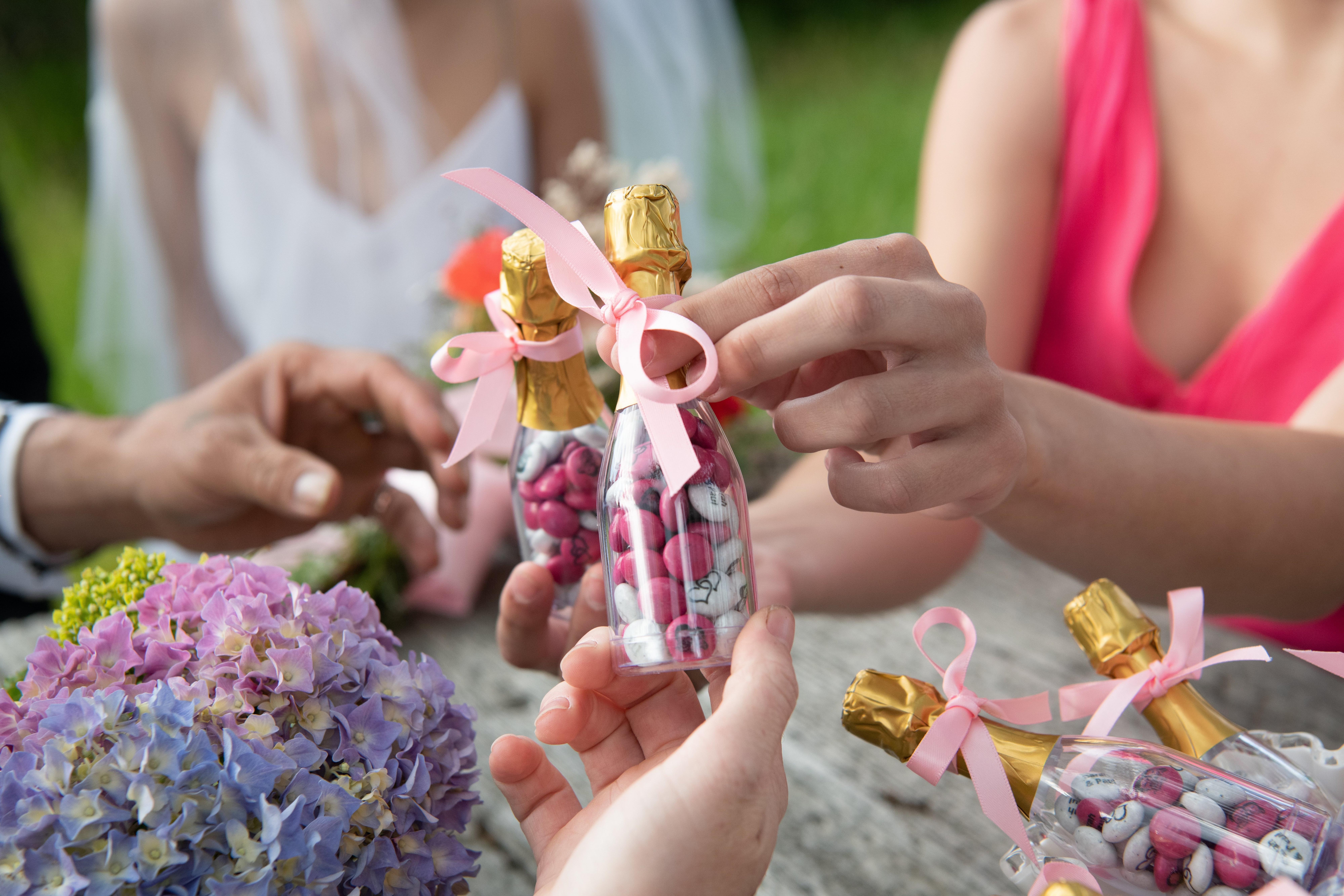 Trois mains avec minis bouteilles M&M's décoration mariage