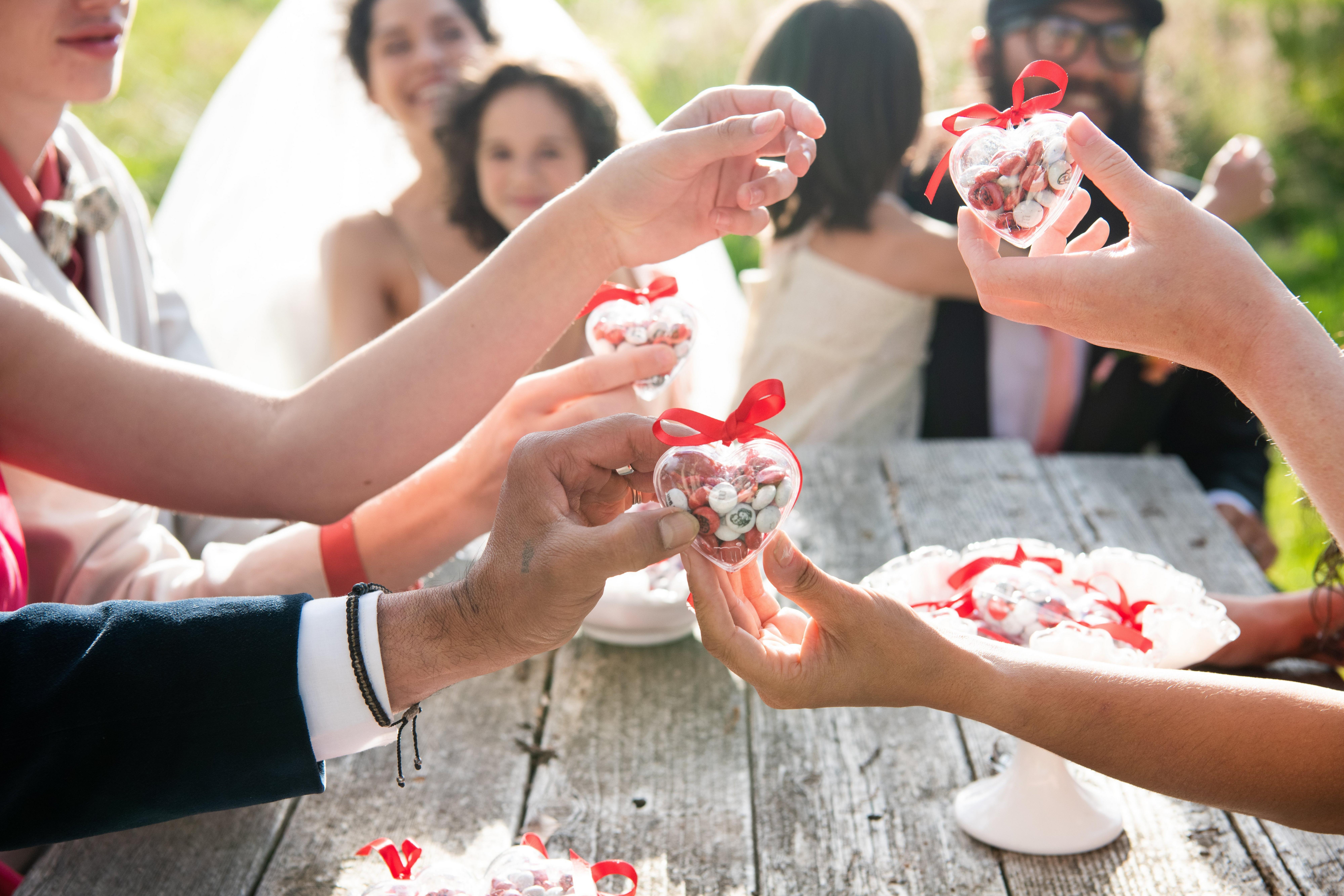 Des petits cœurs remplis de M&M’S rouges et blancs sont offerts lors d’un mariage