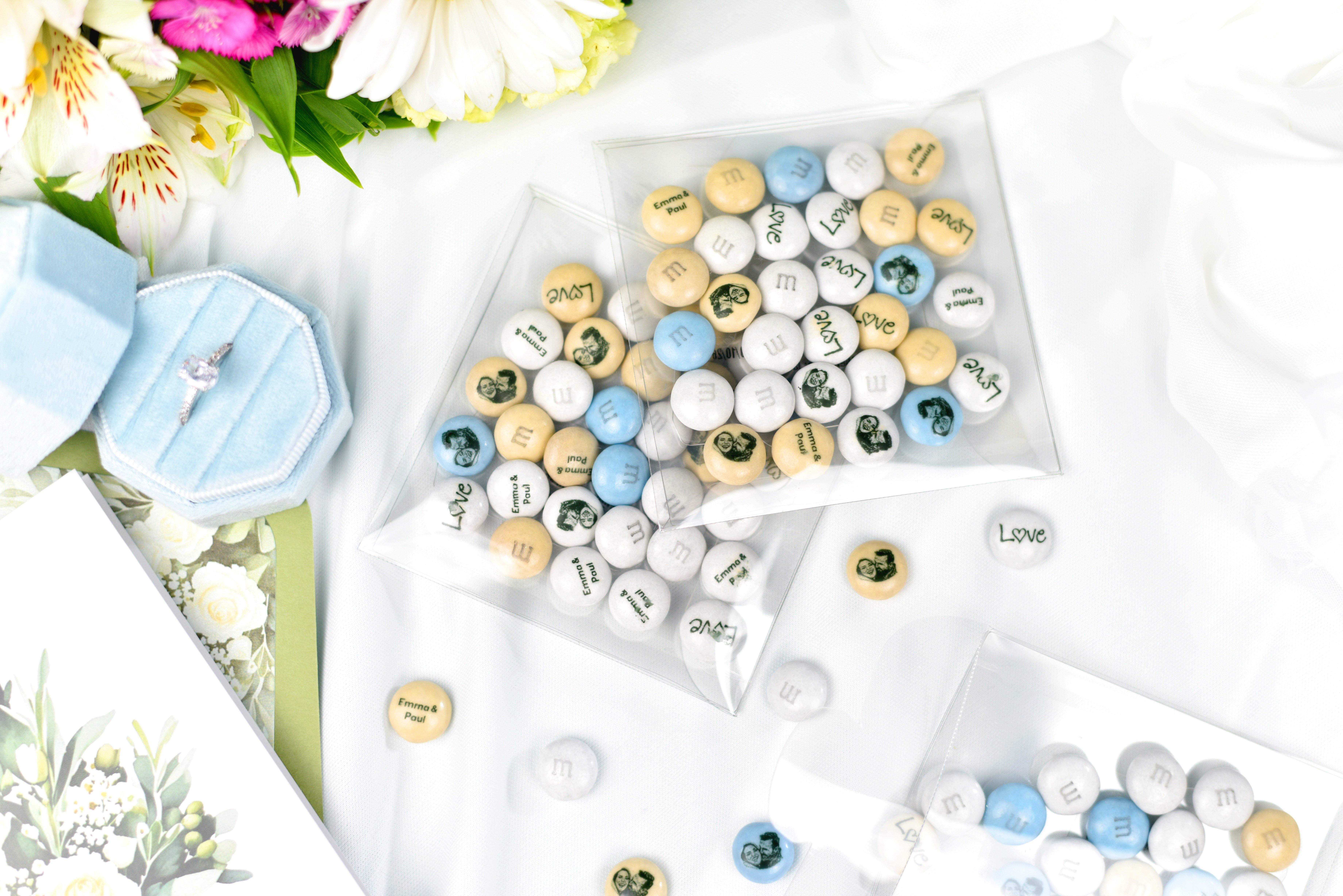 detalles en forma de corazón con M&M'S rojos y blancos repartiéndose en una boda