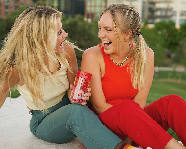 two girls in a park sharing M&M'S