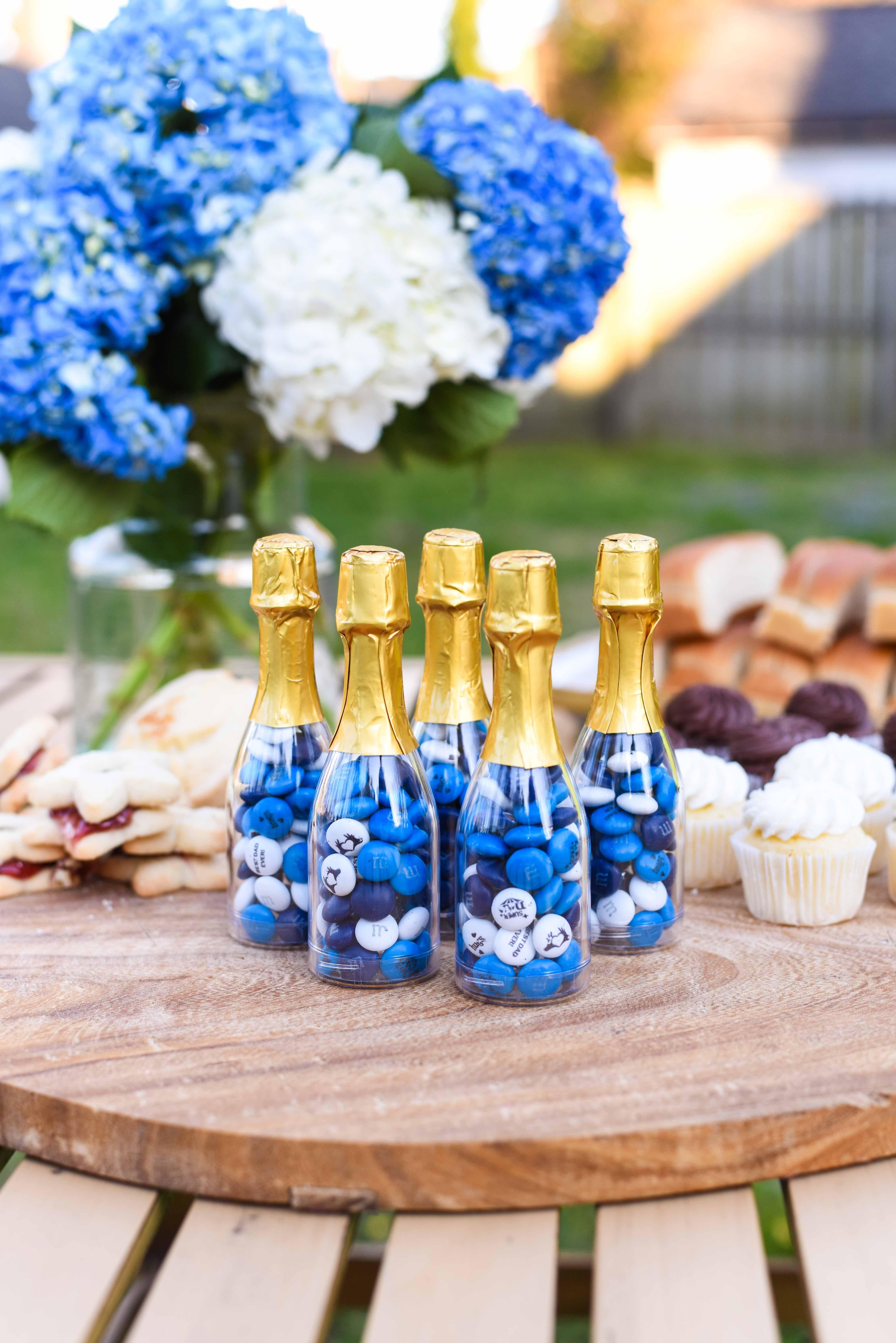 mini occasion bottles filled with personalized M&M'S on table at a BBQ