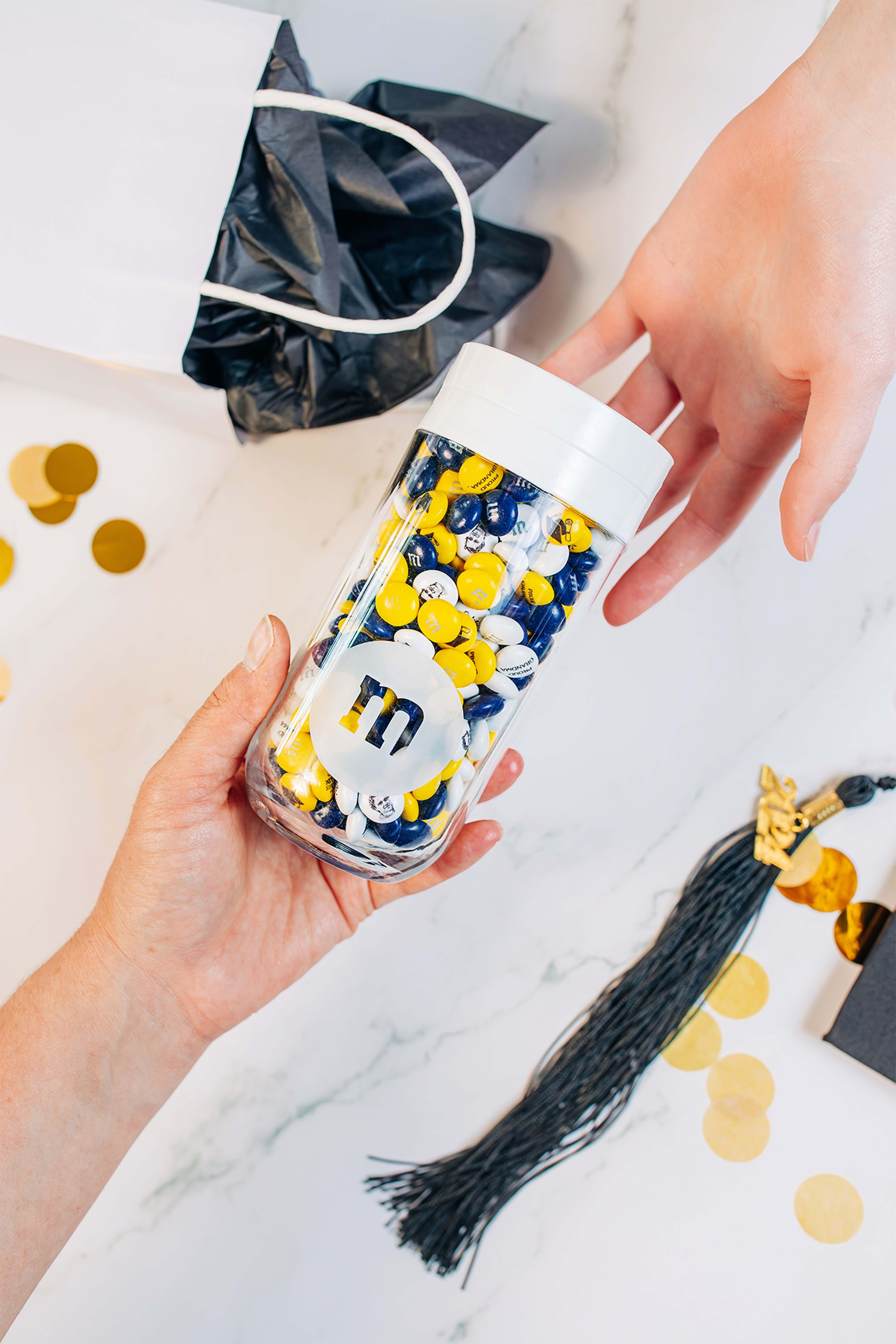 one person handing a gift jar to another person