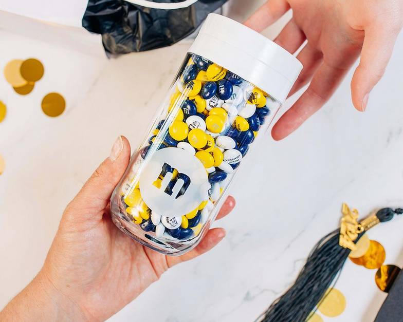 one person handing a gift jar to another person