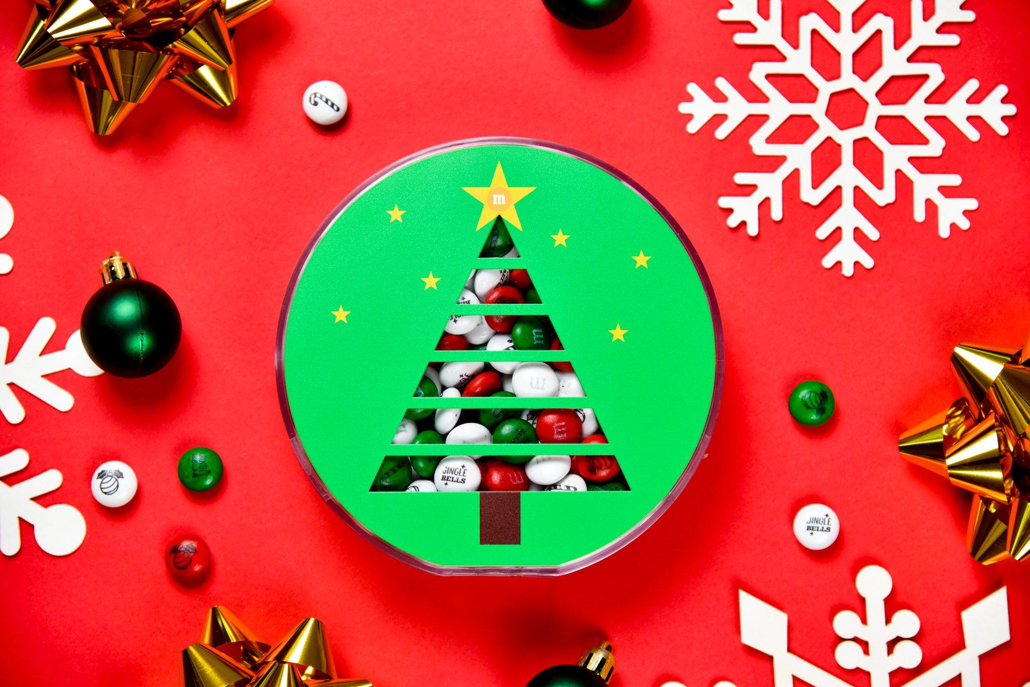 round christmas tree gift box surrounded by christmas decorations
