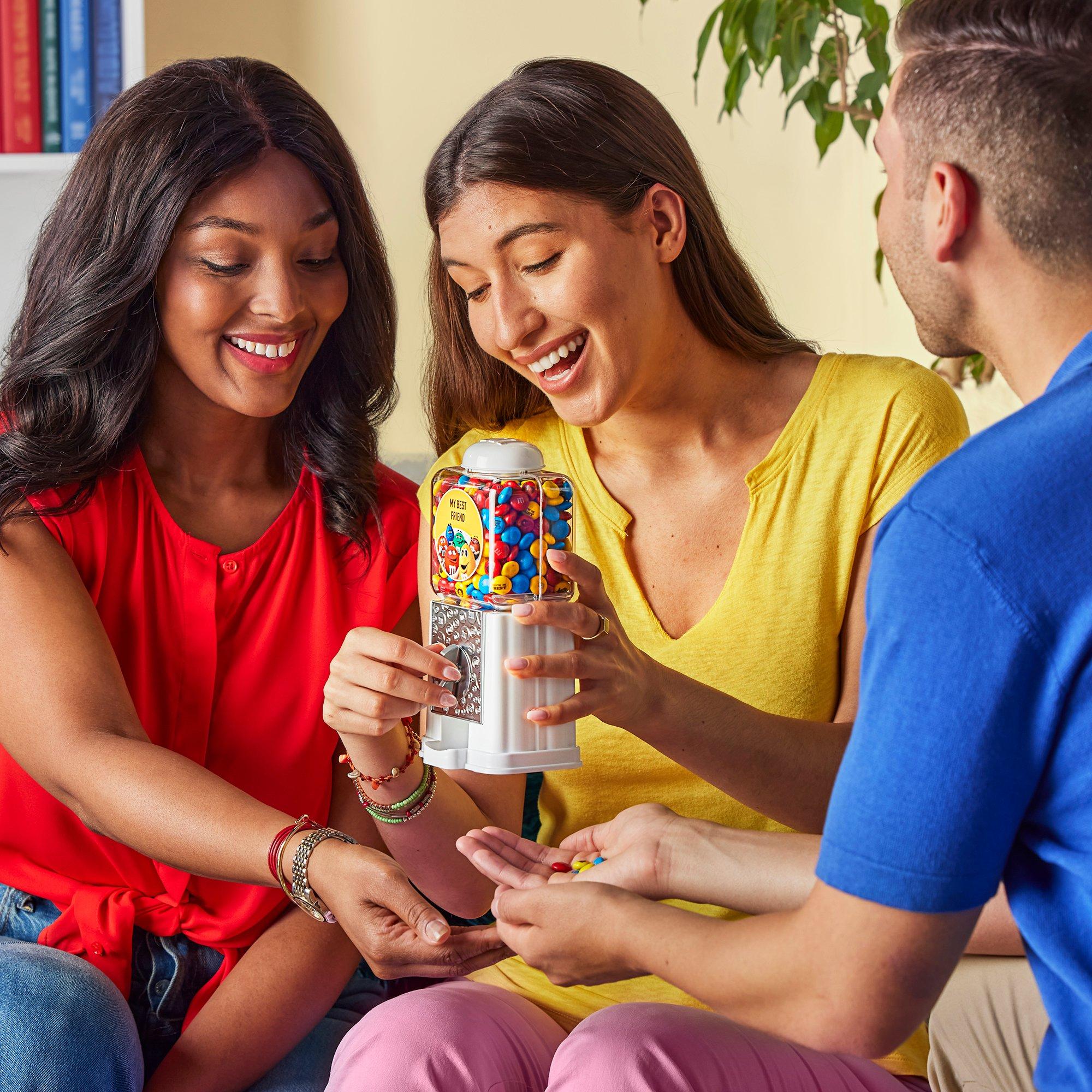 three friends with a dispenser sharing M&M'S