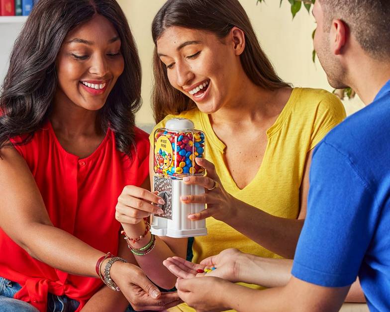 three friends with a dispenser sharing M&M'S
