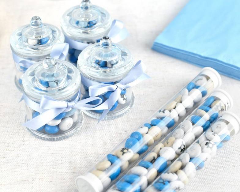 assorted party favors filled with blue and white M&M'S on table