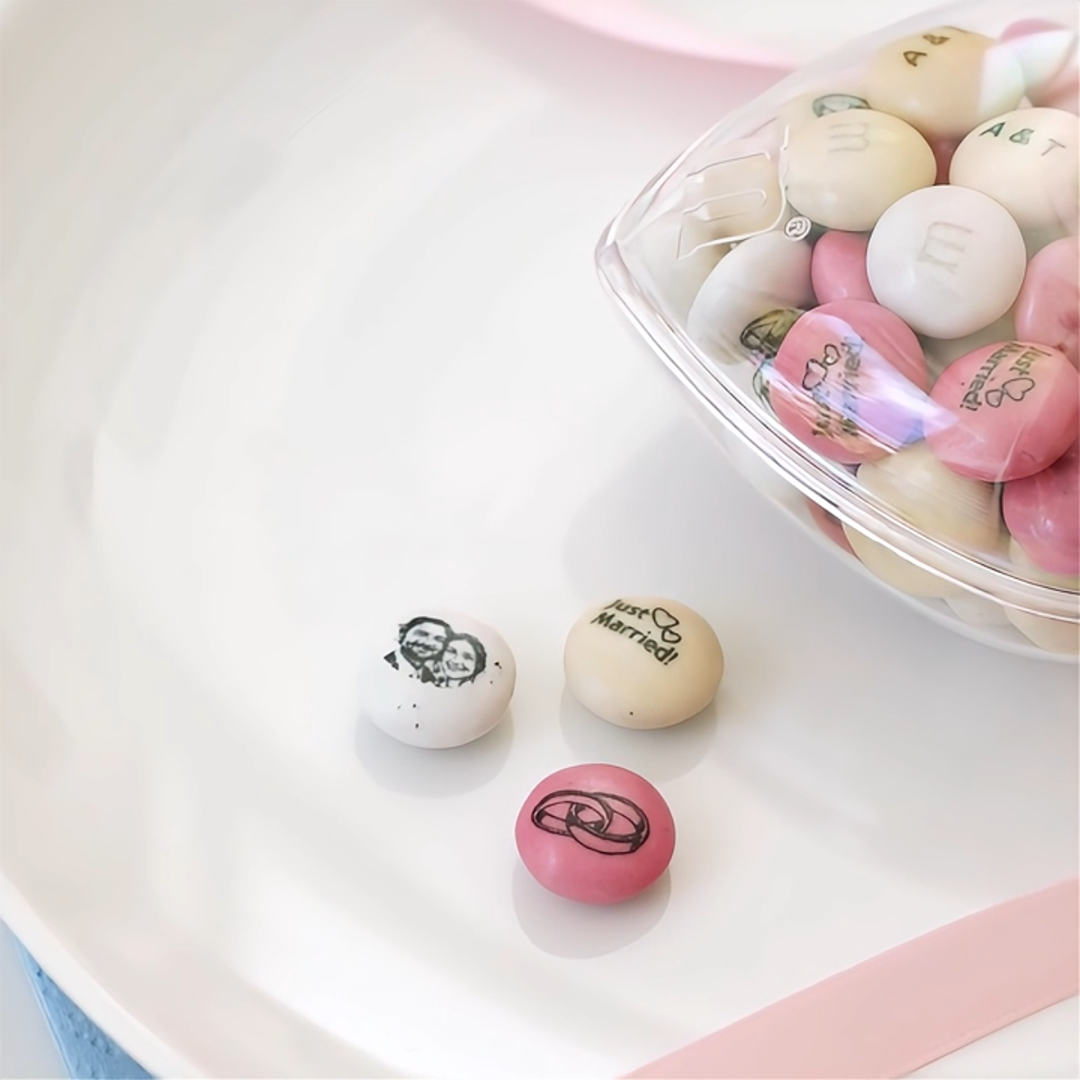 rozdawane na weselu upominki w kształcie serca wypełnione czerwonymi i białymi M&M’S