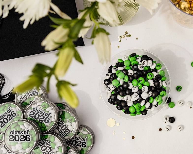a graduation dessert table with M&M'S favors and personalized candy