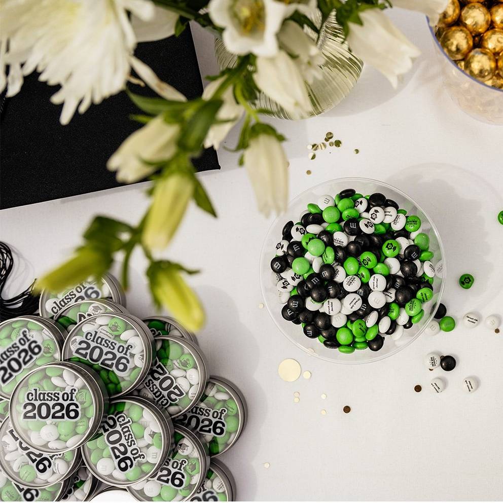 stack of graduation favor tins and a bowl of M&M'S