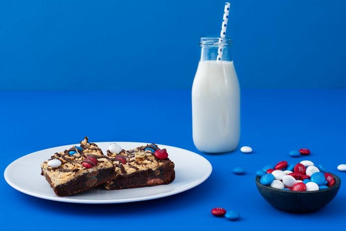 S'mores bites on a plate with a glass of milk and bowl of M&M'S