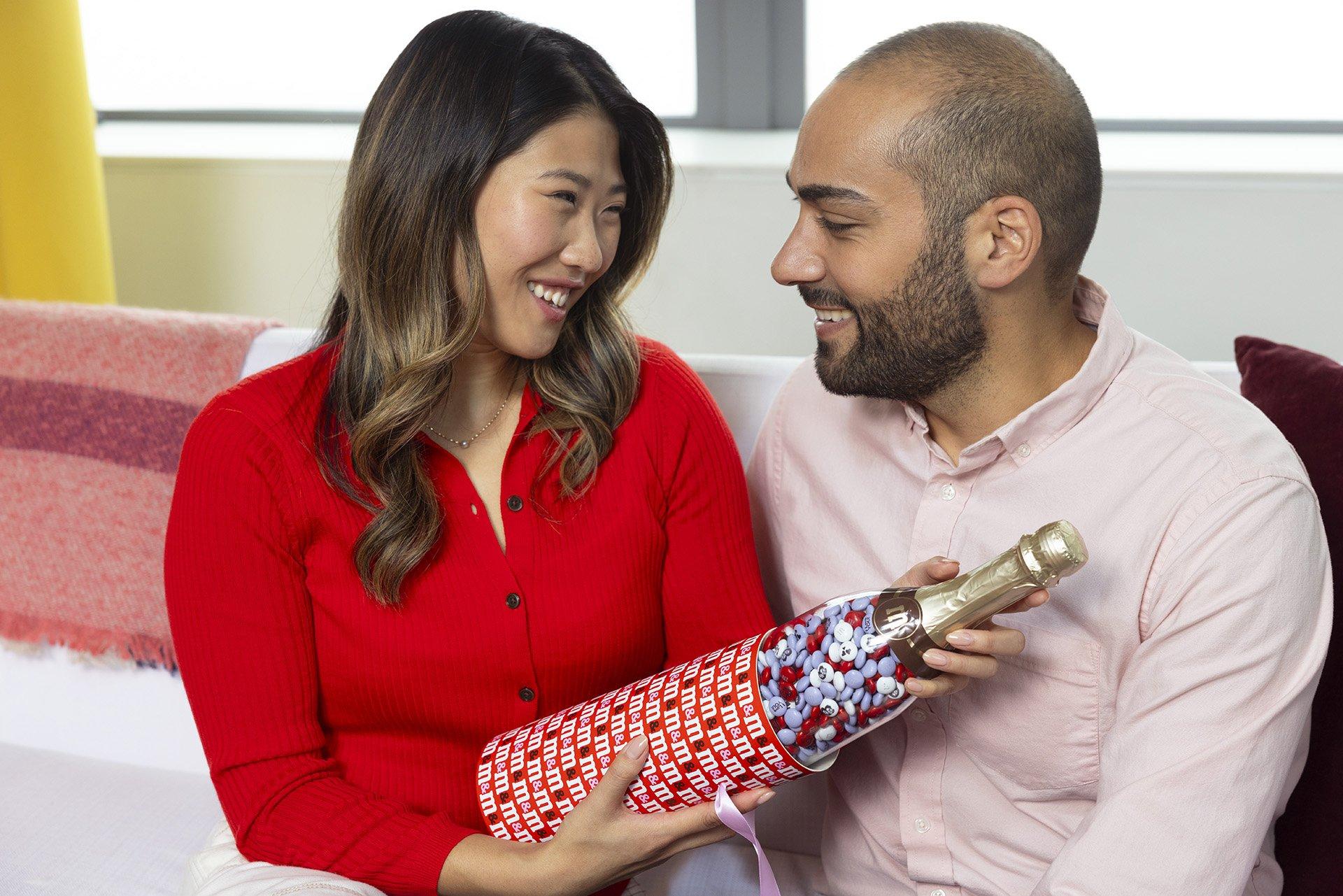 family of four on the couch laughing and enjoying gifting one another for Valentine's Day