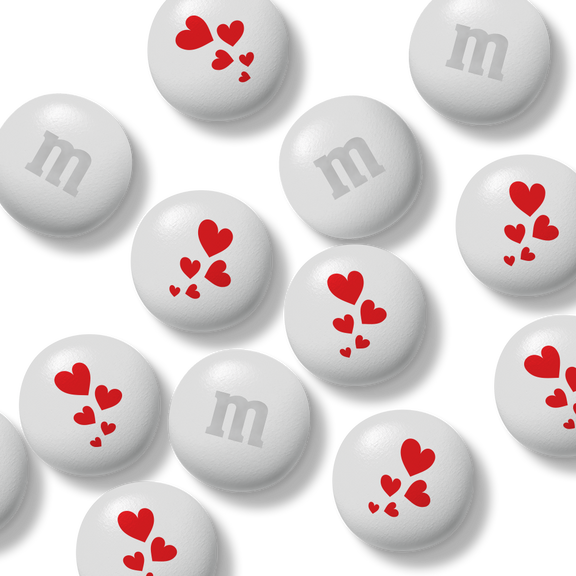 Bag of M&M'S chocolate candies, 32 oz, white with red snowflake pattern, held in a hand.