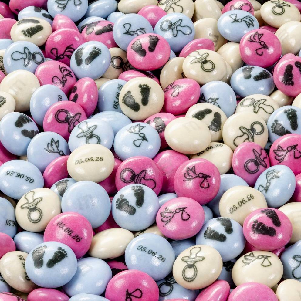M&M'S Schokolinsen in Rosa, Hellblau und Creme mit aufgedruckten Babymotiven wie Schnullern, Fußabdrücken und Kinderwagen.