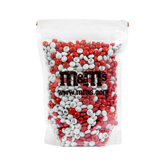 Torba cukierków czekoladowych M&M'S w kolorach czerwonym i białym z logo M&M'S i napisem www.mms.com widocznym przez przezroczyste opakowanie.