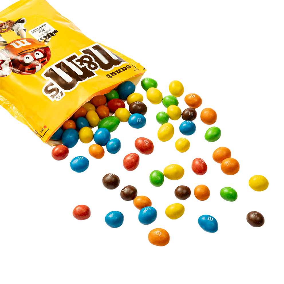 Gele zak M&M'S pinda chocolade snoepjes met kleurrijke snoepjes die uit de geopende verpakking stromen.