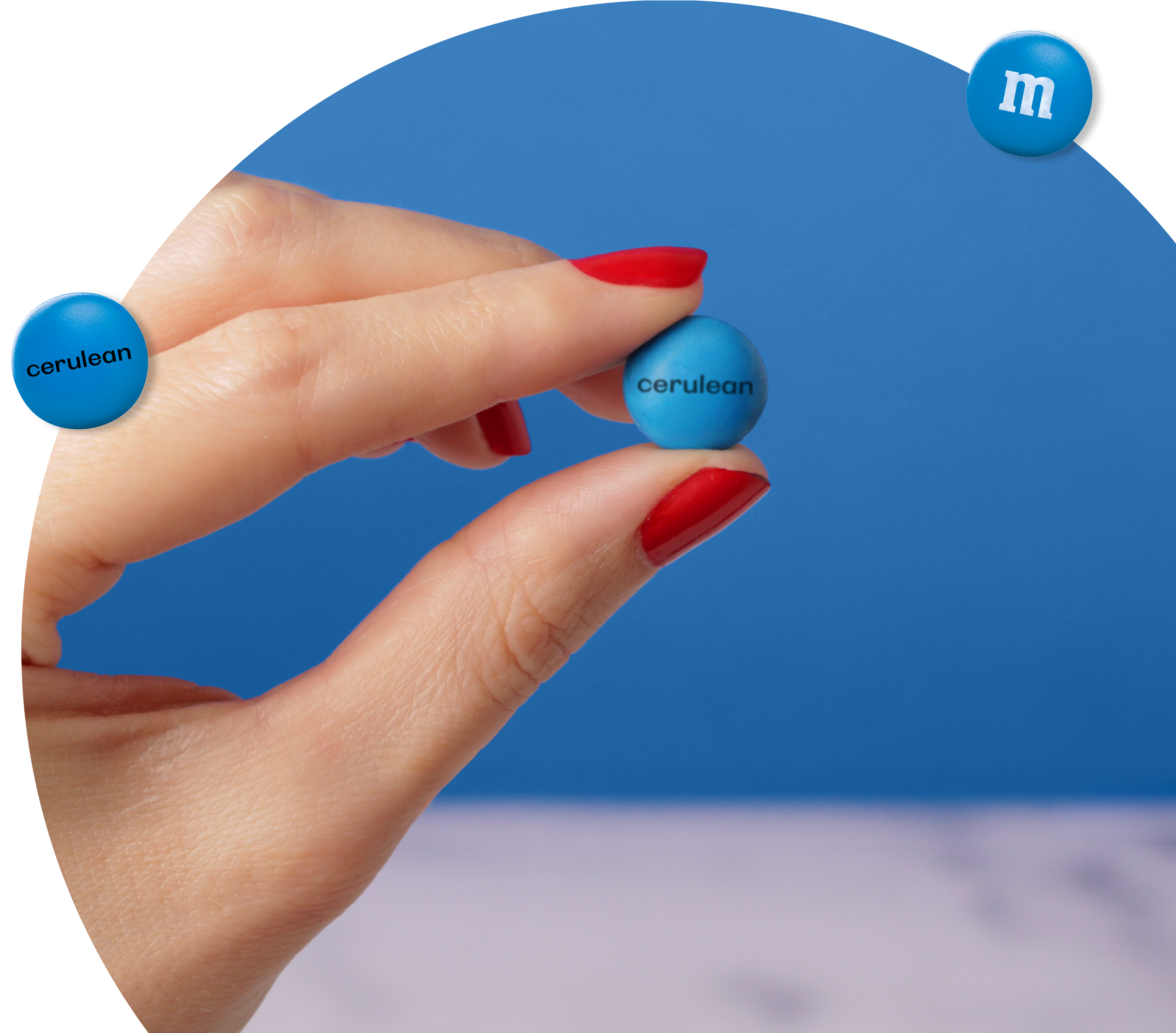 Hand holding M&M'S All Cerulean candies.