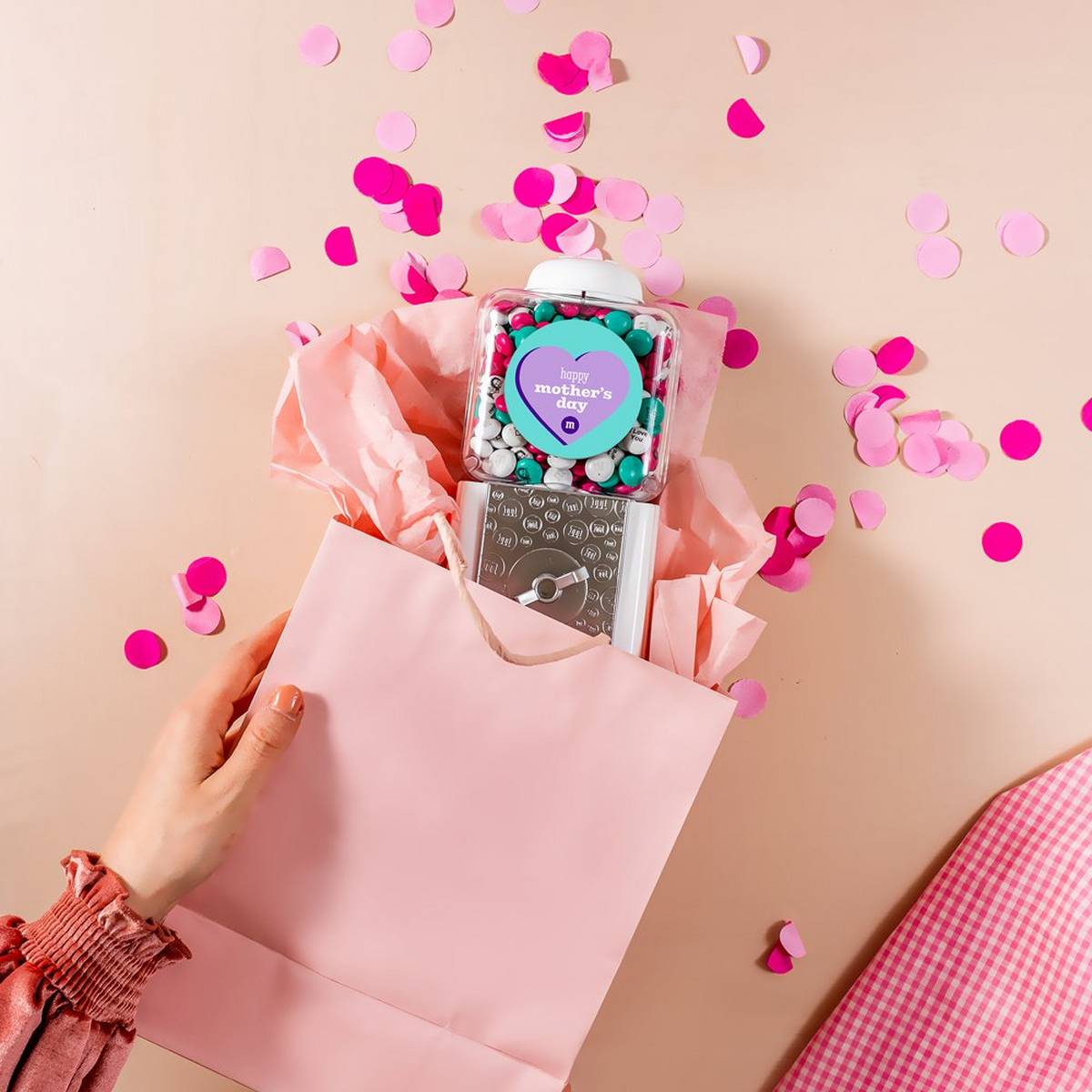 Mother's Day dispenser in gift bag with two hands holding the bag