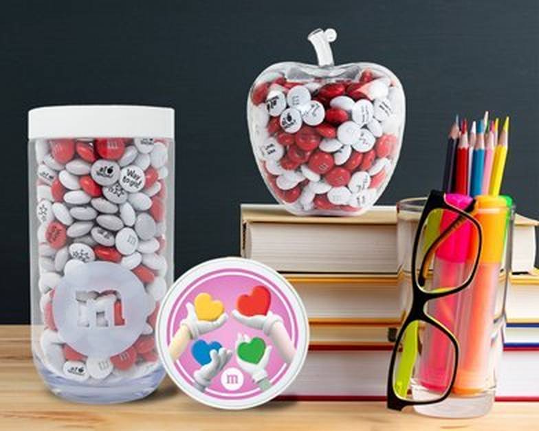 M&M'S Hand of Love Gift Jar and Apple gift jar on desk with books, glasses and pencils