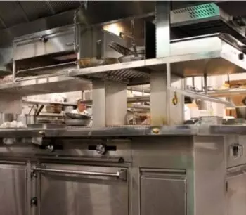 Commercial kitchen with stainless steel appliances and shelves.