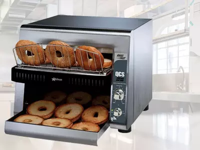 Star toaster oven with bagels on top rack and toasted bagels on bottom tray.
