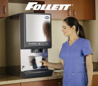 Woman in scrubs using Follett Symphony ice dispenser.