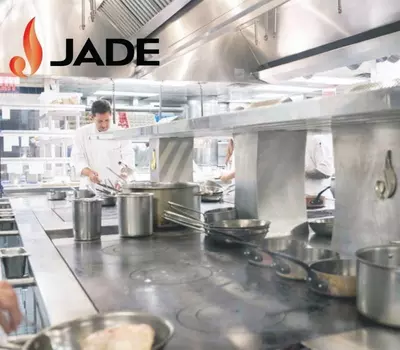 Chef working in a professional kitchen with JADE branding visible.