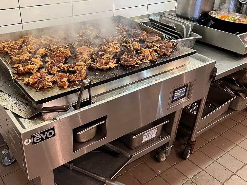 a photo showing meat cooking on a high-performance commercial griddle