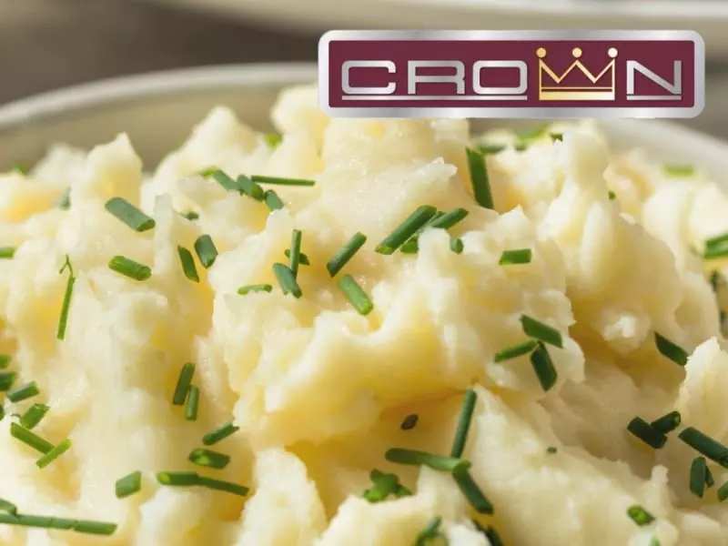 Mashed potatoes topped with chopped chives, "Crown" logo in the corner.
