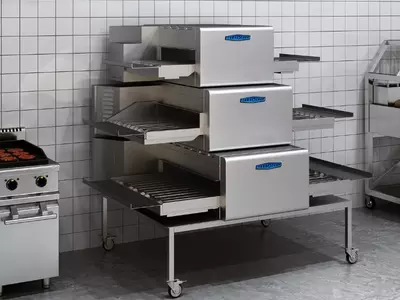 Triple-tier stainless steel conveyor oven with TurboChef branding in a tiled kitchen.