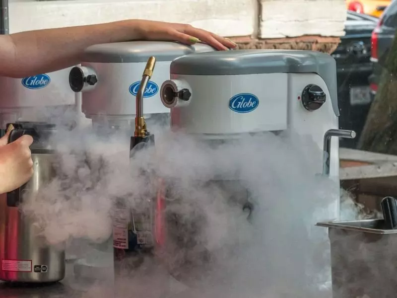 Globe-branded machines surrounded by vapor, with a hand adjusting a control.