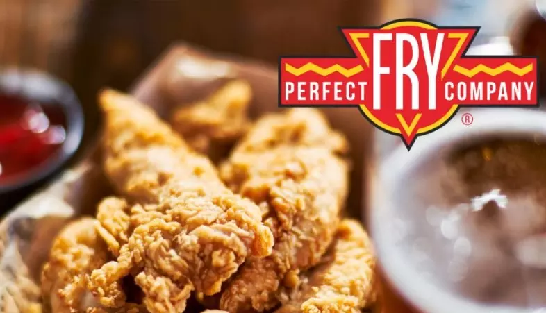 Crispy fried chicken tenders in a basket, with a glass of beer and ketchup nearby. Perfect Fry logo visible.