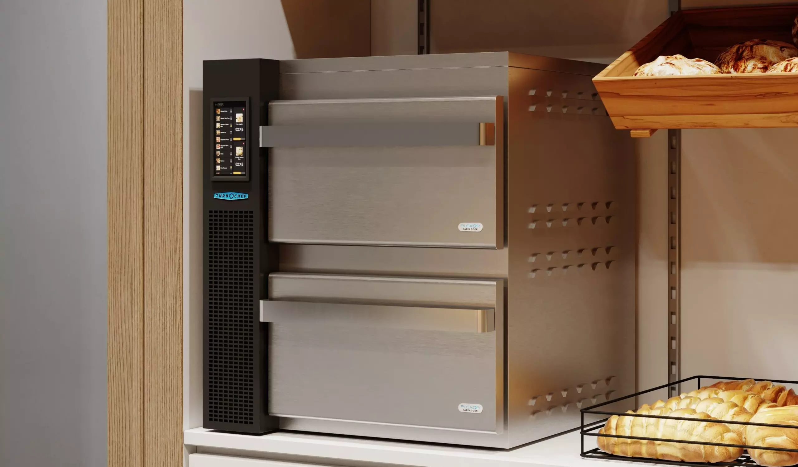 Silver oven with two compartments, digital display, next to baked goods on a counter.