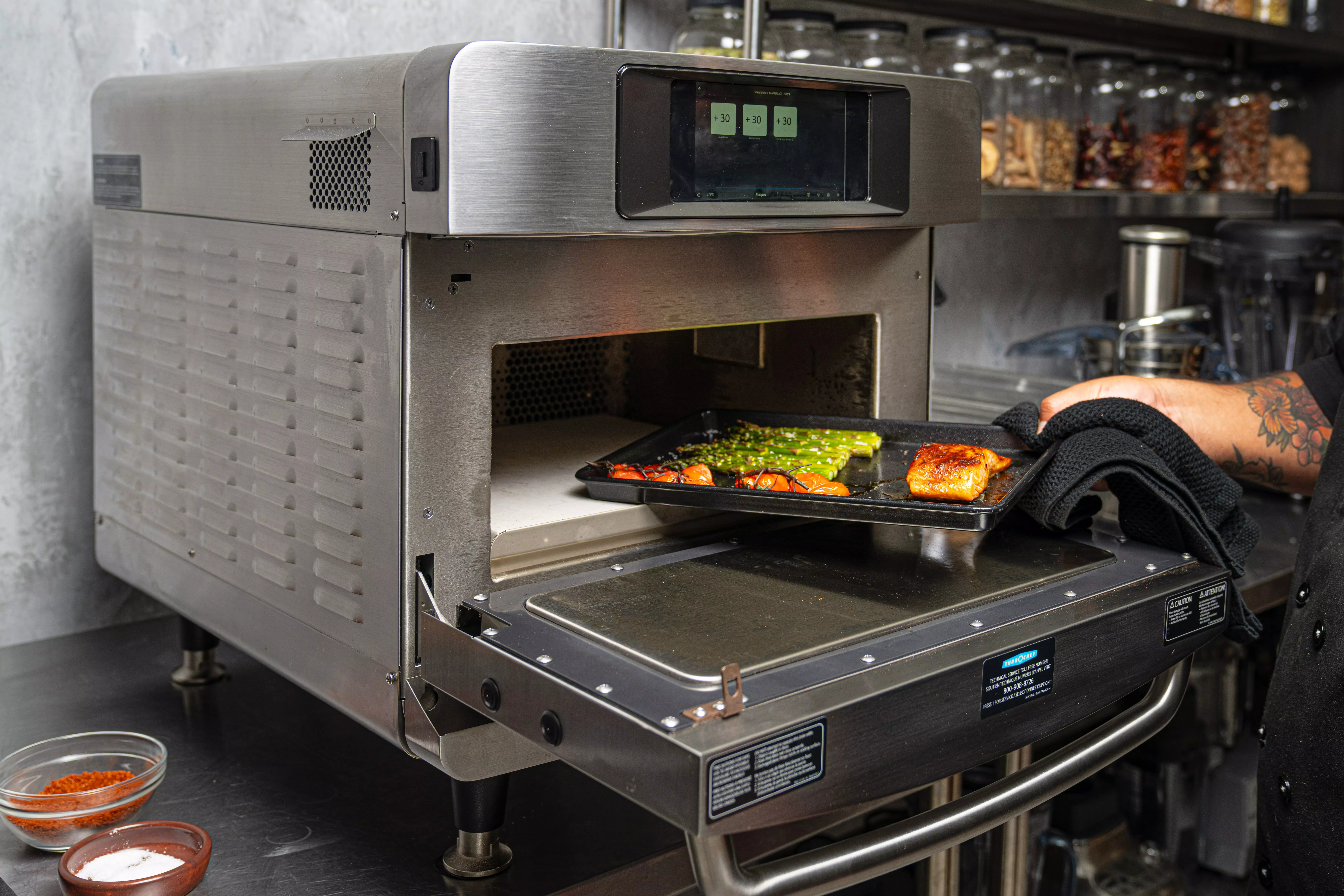 a chef cooking salmon in a rapid-cook oven that’s built for high performance
