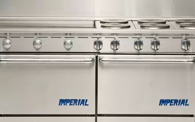 Stainless steel Imperial stove with six control knobs and oven doors.