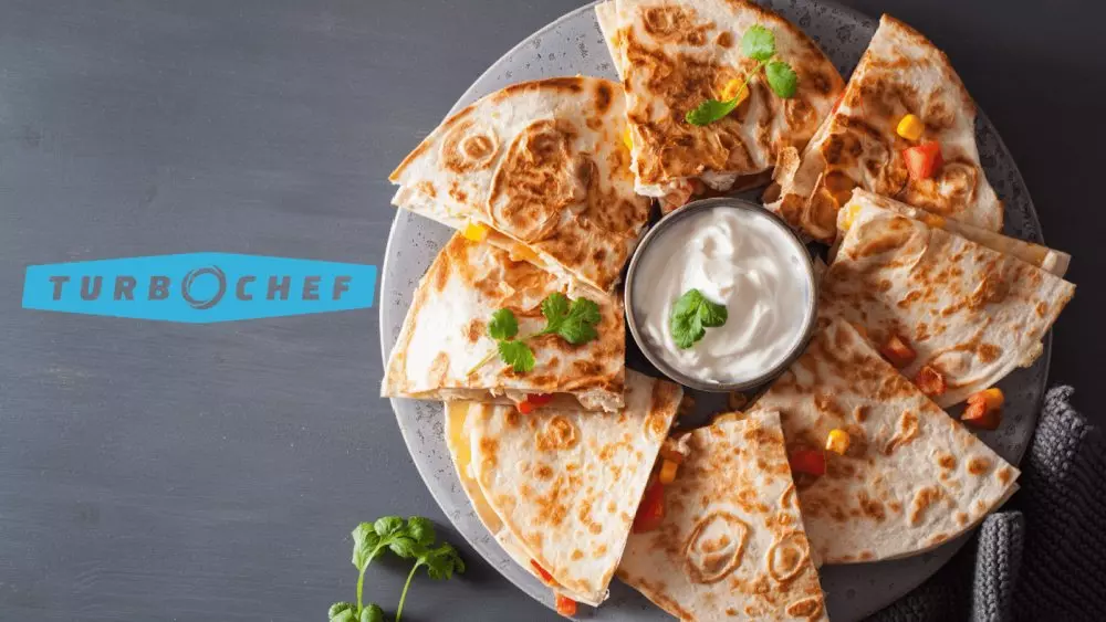 Plate of quesadilla slices with sour cream dip. TurboChef logo visible.