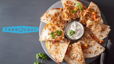 Plate of quesadilla slices with sour cream dip. TurboChef logo visible.