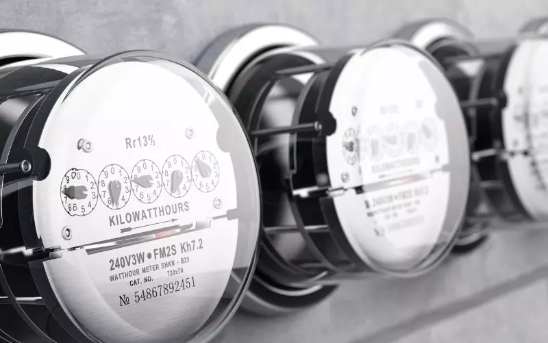 Row of electric meters displaying kilowatt hours and technical details.