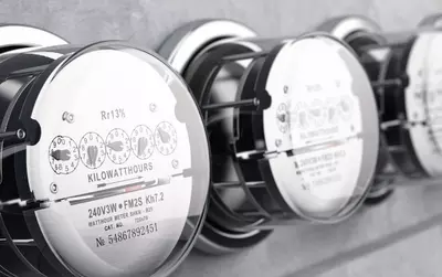 Row of electric meters displaying kilowatt hours and technical details.