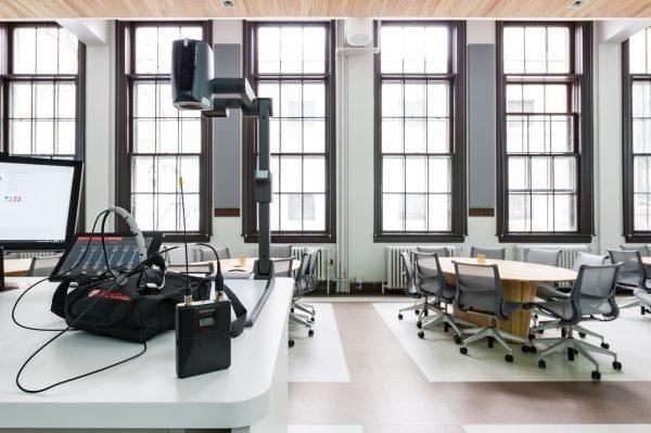 a room with a desk and a computer on it and the Shure QLX-D wireless system