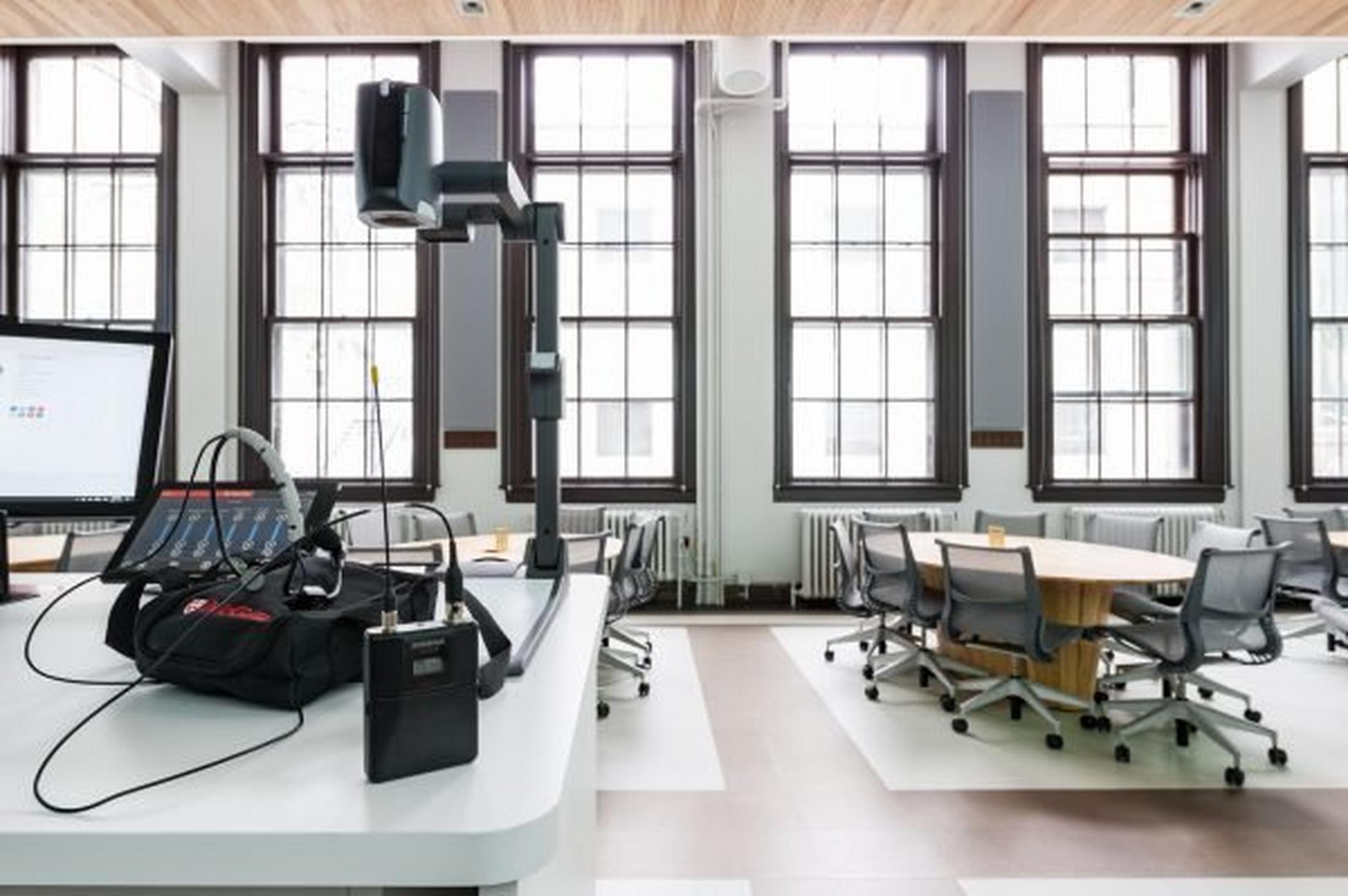 a room with a desk and a computer on it and the Shure QLX-D wireless system