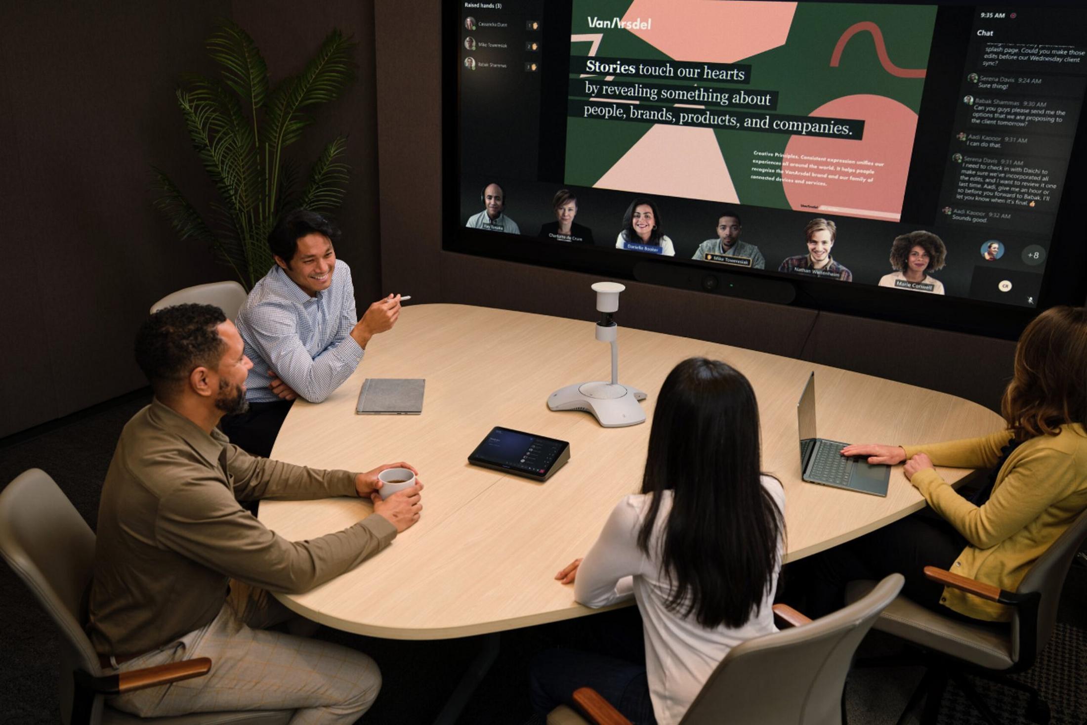 a group of people sitting around a table with laptops