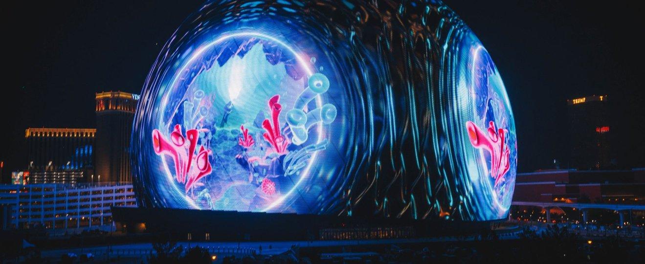 a large illuminated sculpture of a fish in the middle of a city