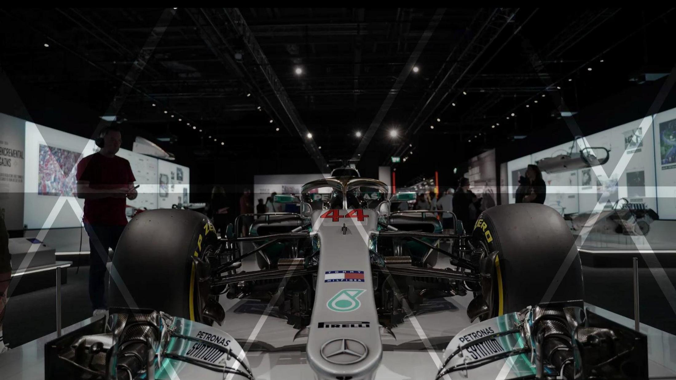 a car on display in a museum with people looking at it