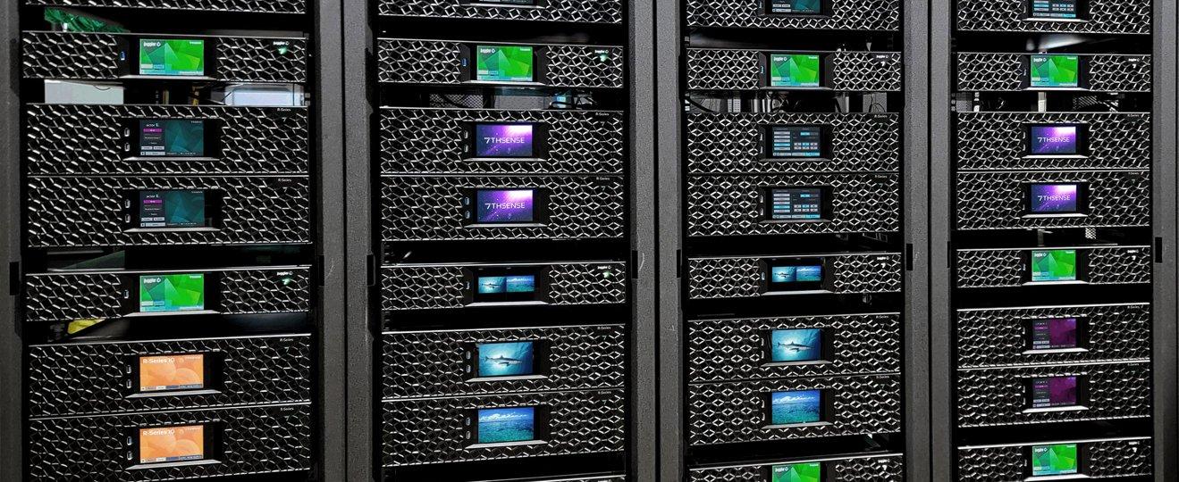 a man standing in front of a large black server rack